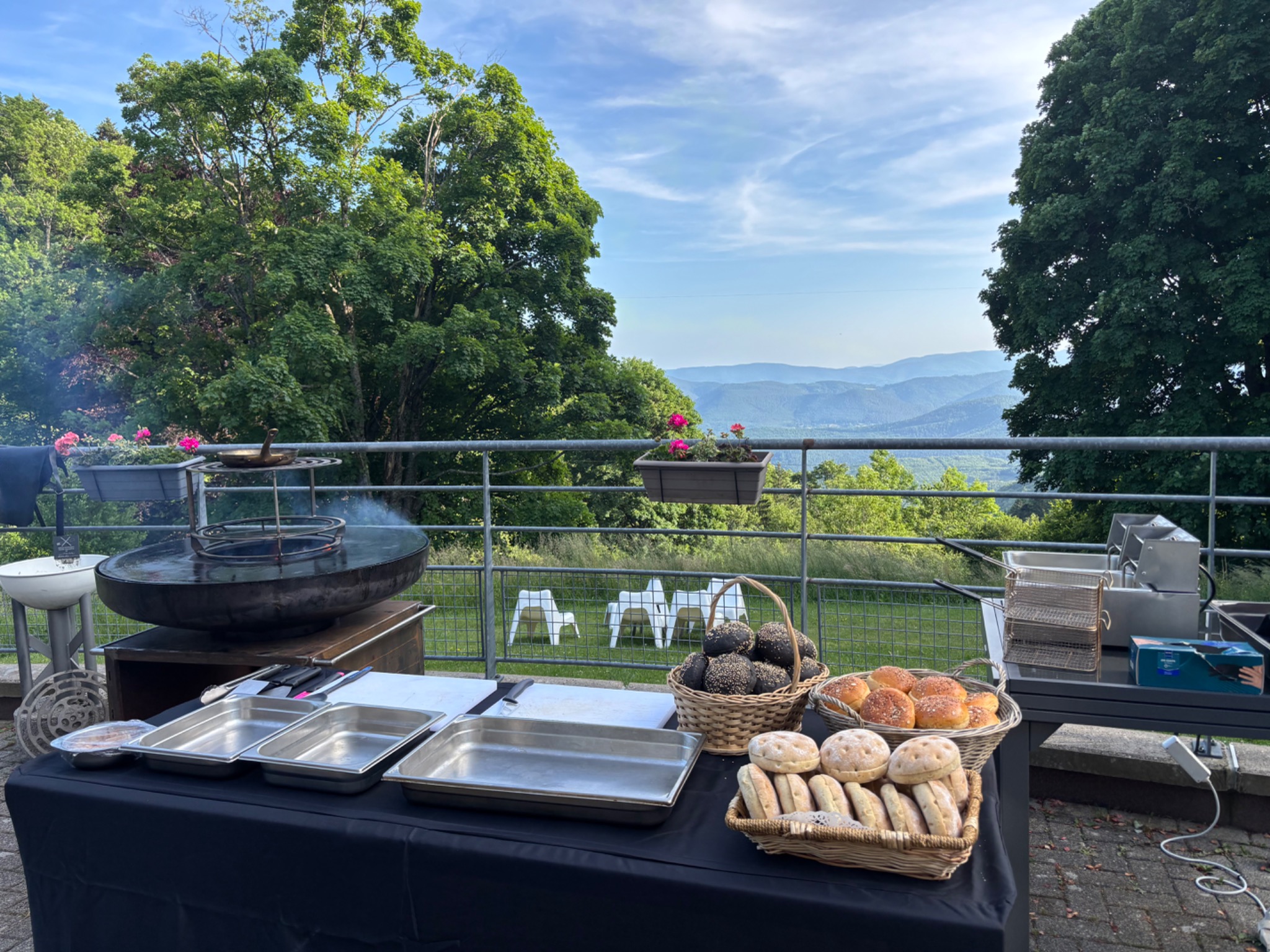 Buffet préparé en extérieur avec le brasero et les Vosges en arrière-plan
