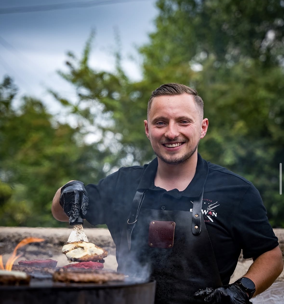 Erwan prépare des burgers au brasero pendant une prestation